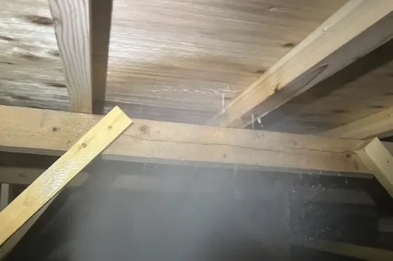 福岡県北九州市の築15年住宅の床下で、木部へシロアリ予防薬剤を散布している様子