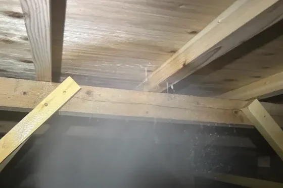 専用のノズルを使い、床下の土台や大引きといった木部へシロアリ予防薬剤を噴霧している様子。