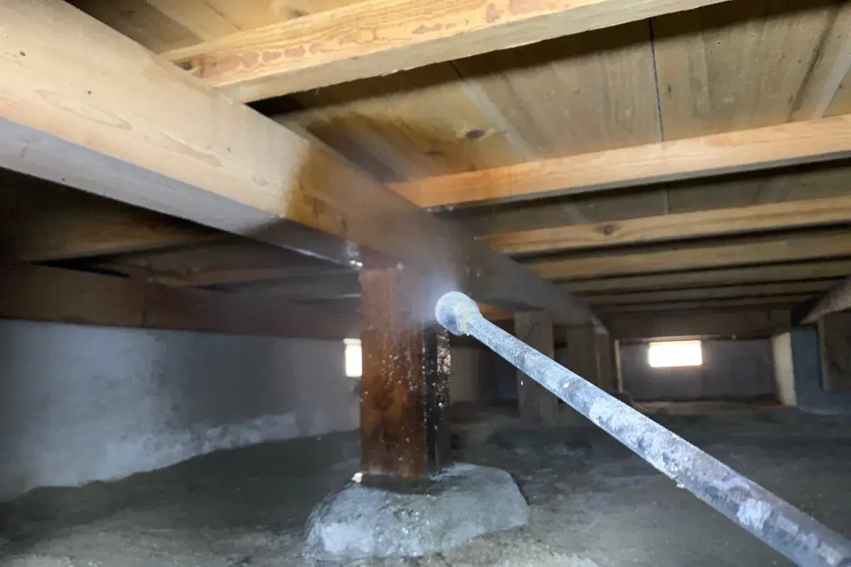 狭い床下の隅々まで薬剤を散布する熟練スタッフの施工の様子