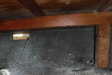 築35年の住宅床下にて、木部と土壌へ薬剤を全面散布する様子
