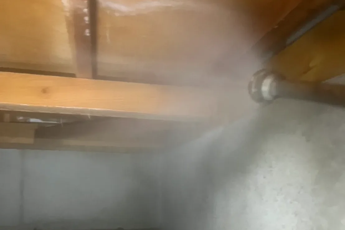 床下の木材に対して、広範囲に薬剤を噴霧する様子