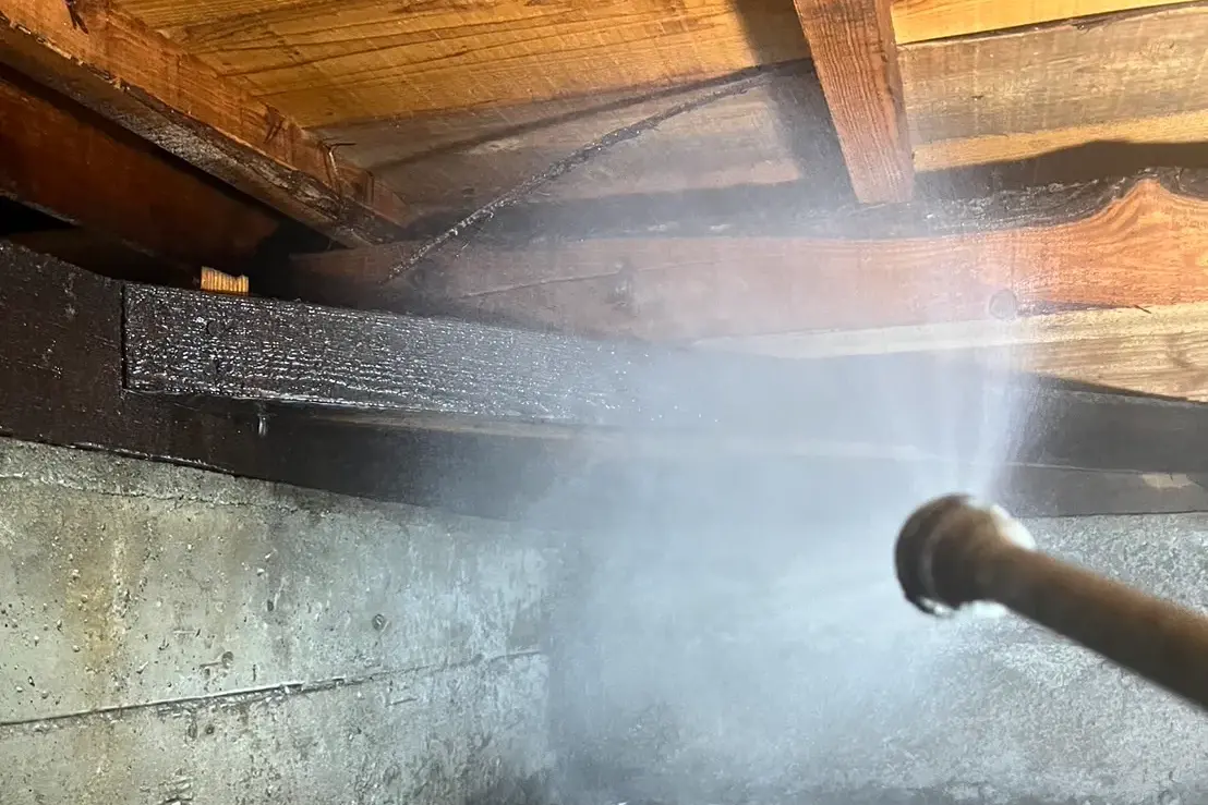 基礎と接する重要な木材部分へ薬剤を散布している様子