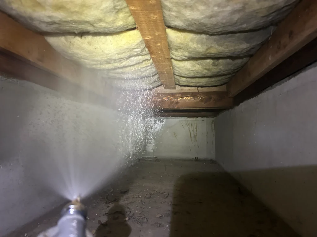 大分県別府市の築30年の住宅にて床下シロアリ予防施工にて、噴霧器を使い木部へ薬剤を霧状に散布している様子