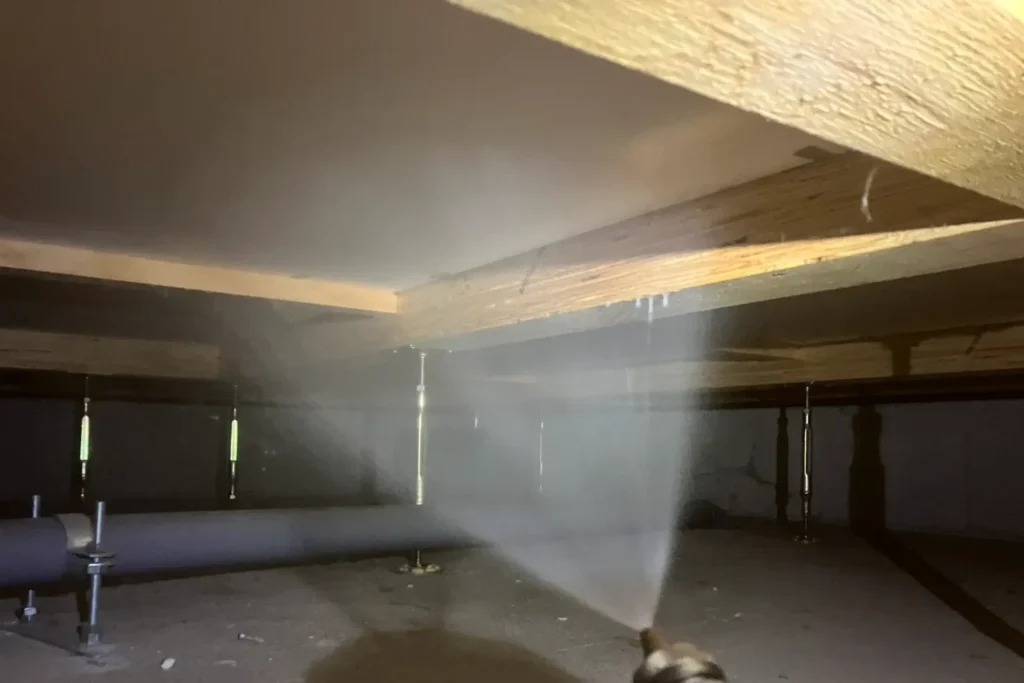 熊本県玉名市でのシロアリ予防施工。床下木材への薬剤散布によるバリア形成作業