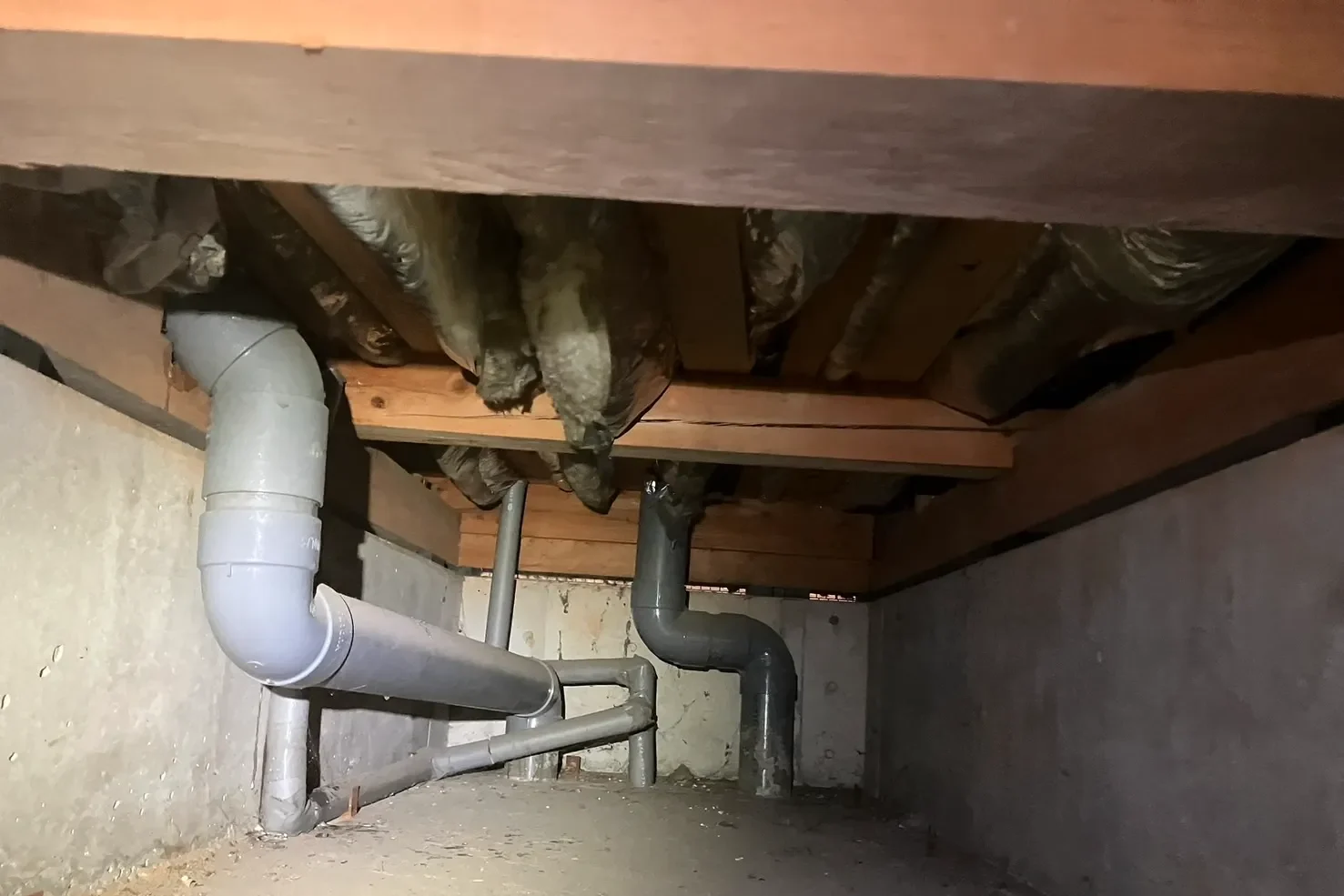 築25年の住宅床下。配管と経年で垂れ下がった断熱材の調査状況。