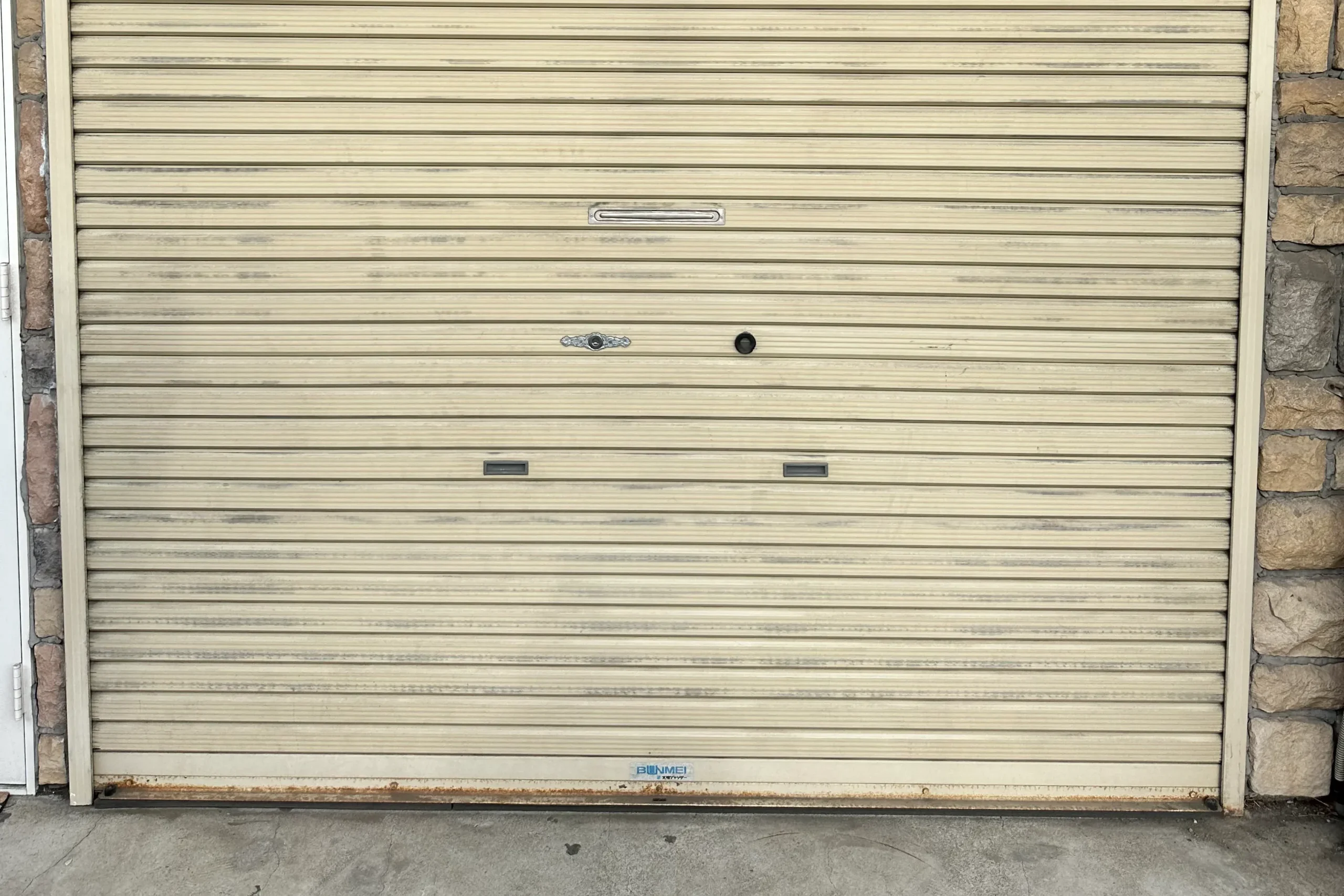 塗装前で色あせや汚れが目立つガレージシャッターの全景