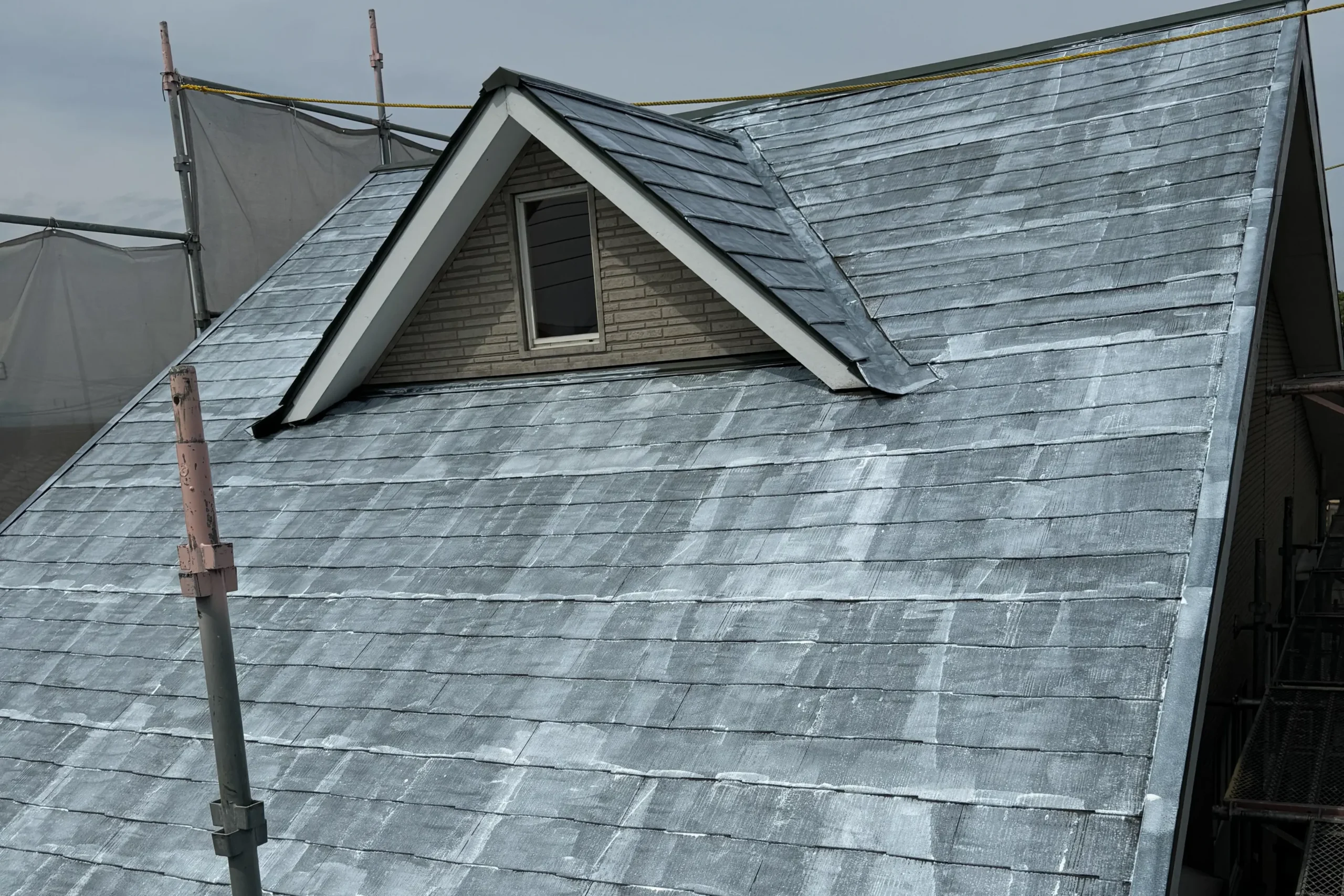 高圧洗浄後、屋根材と上塗り塗料を密着させるために白く塗られた下塗りの様子