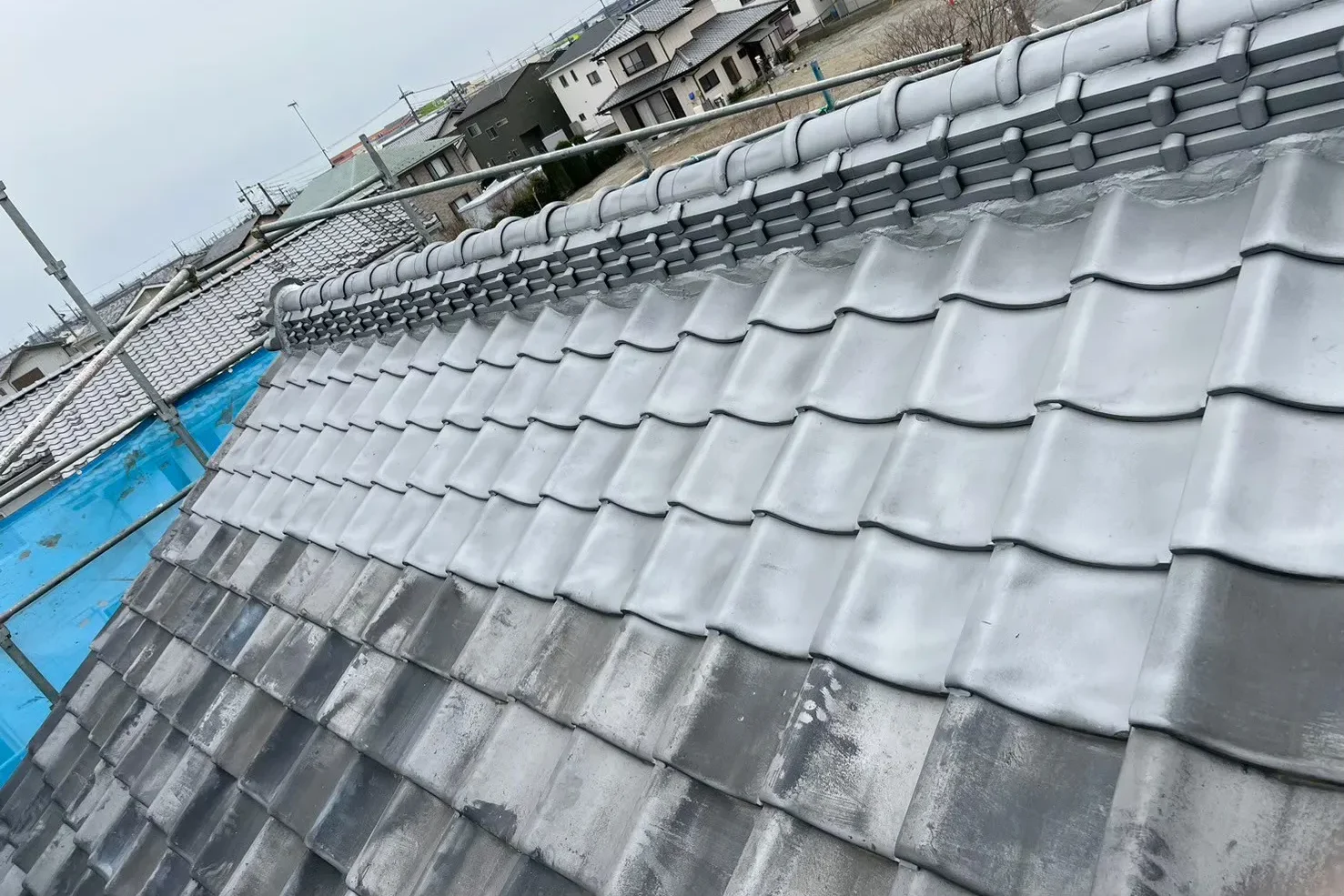 瓦屋根の塗装工程。塗装前後で色と艶が劇的に変化している様子。