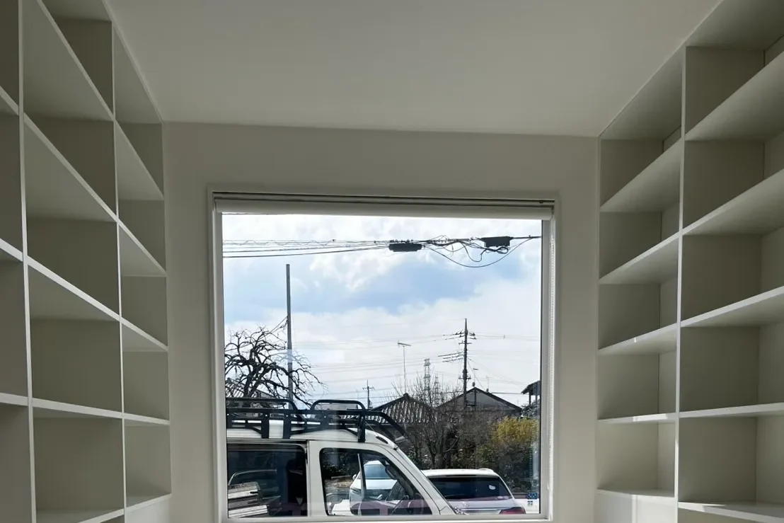 兵庫県神戸市の新築住宅にて施工した、窓を囲む白い壁面本棚の完成写真。