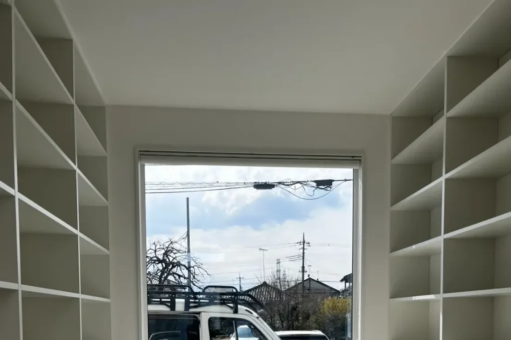 神戸市の戸建て住宅におけるオーダー家具施工事例。光を遮らない窓枠フィット設計の天井高壁面収納。