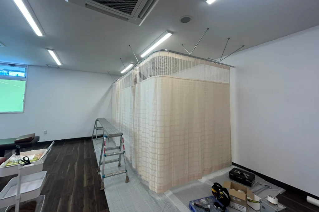 京都市内の整骨院にてカーテンレール取付工事。築10年の綺麗な内装に馴染むアイボリーの間仕切り。