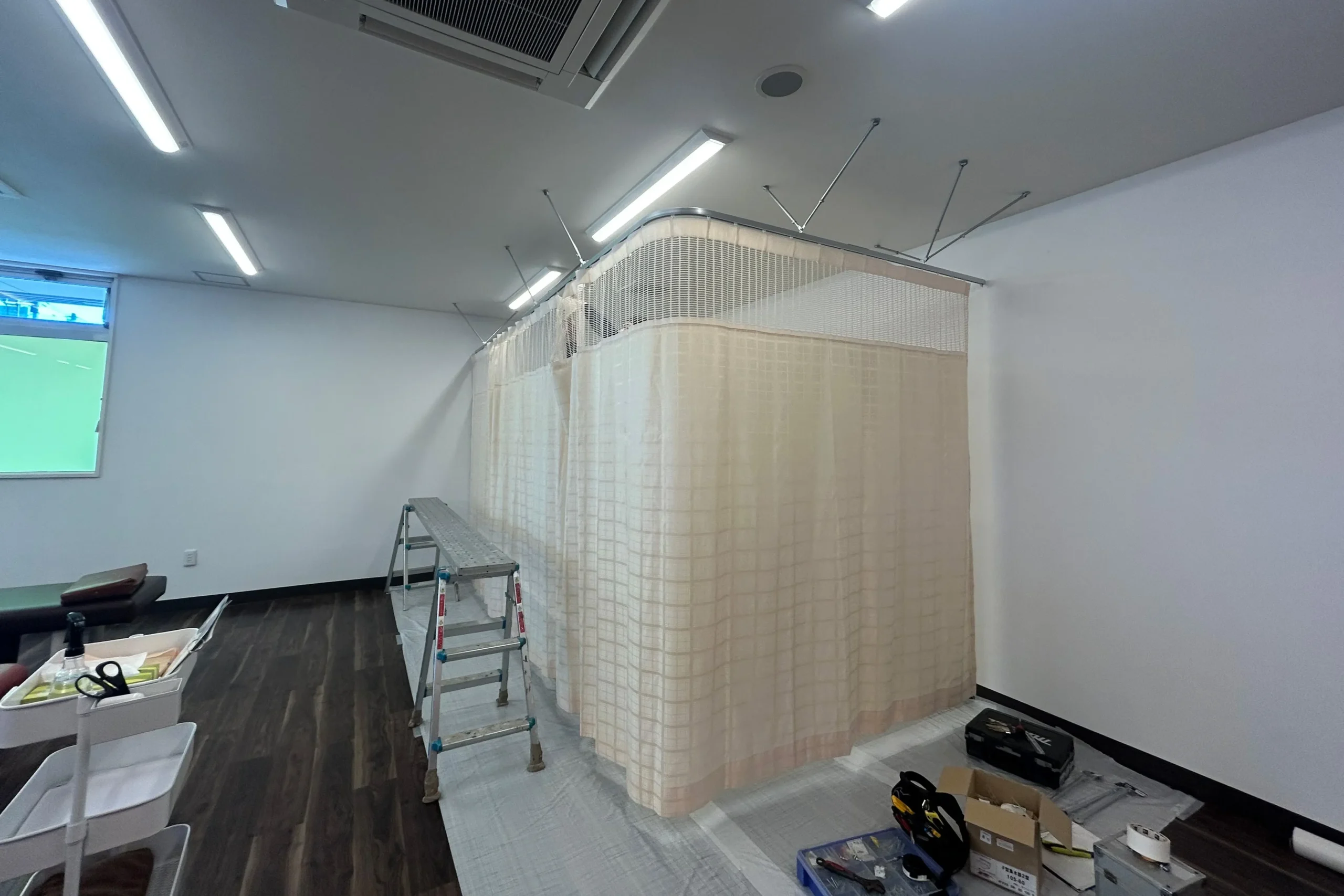 完成したL字型の病院用カーテン。上部メッシュ仕様のアイボリー色カーテンでプライバシーを確保。