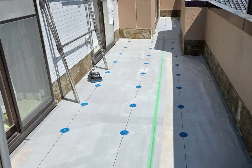 通気緩衝工法による絶縁シートと青いディスクの設置風景