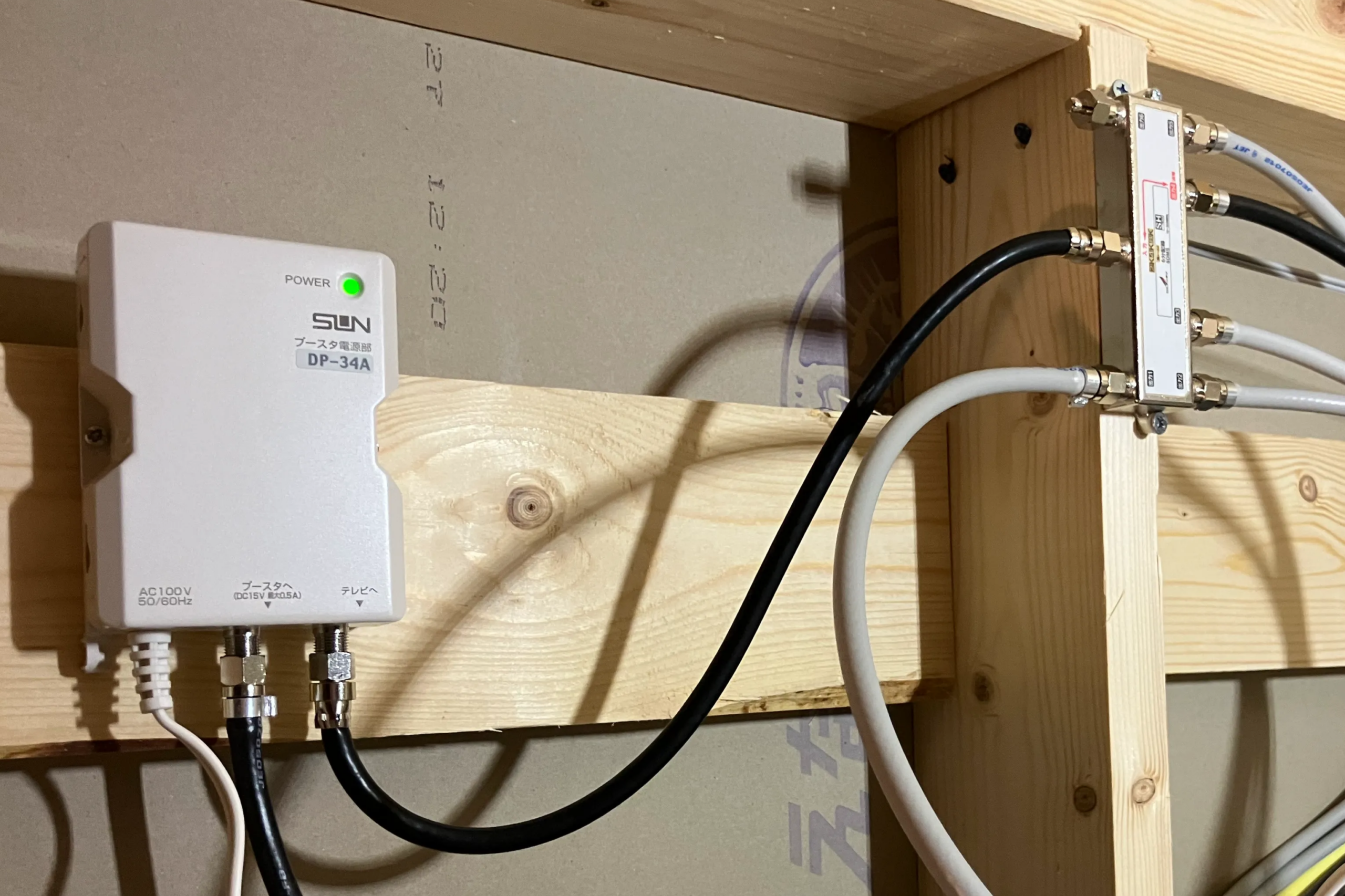 天井裏の点検口内に設置されたテレビ電波の分配器と、屋外ブースター増幅部に、配線が綺麗に整線されて接続されている様子