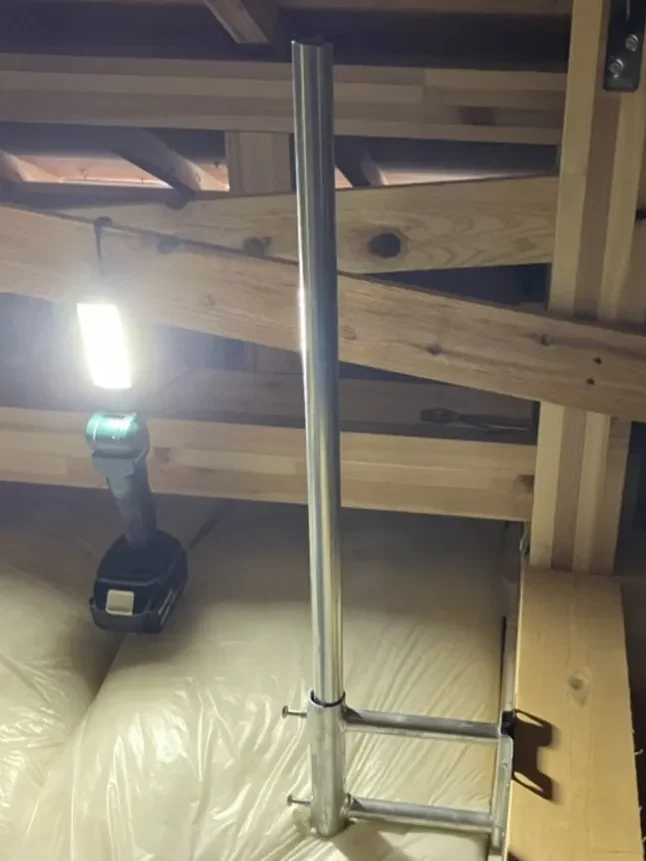 高崎市の新築住宅の屋根裏でサイドベース金具とアンテナマストを設置している様子