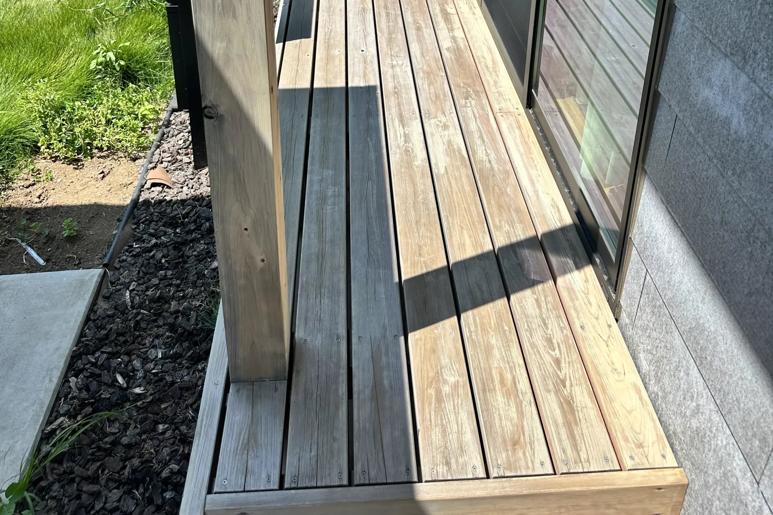 塗装メンテナンス前のグレー化したウッドデッキの床板と柱