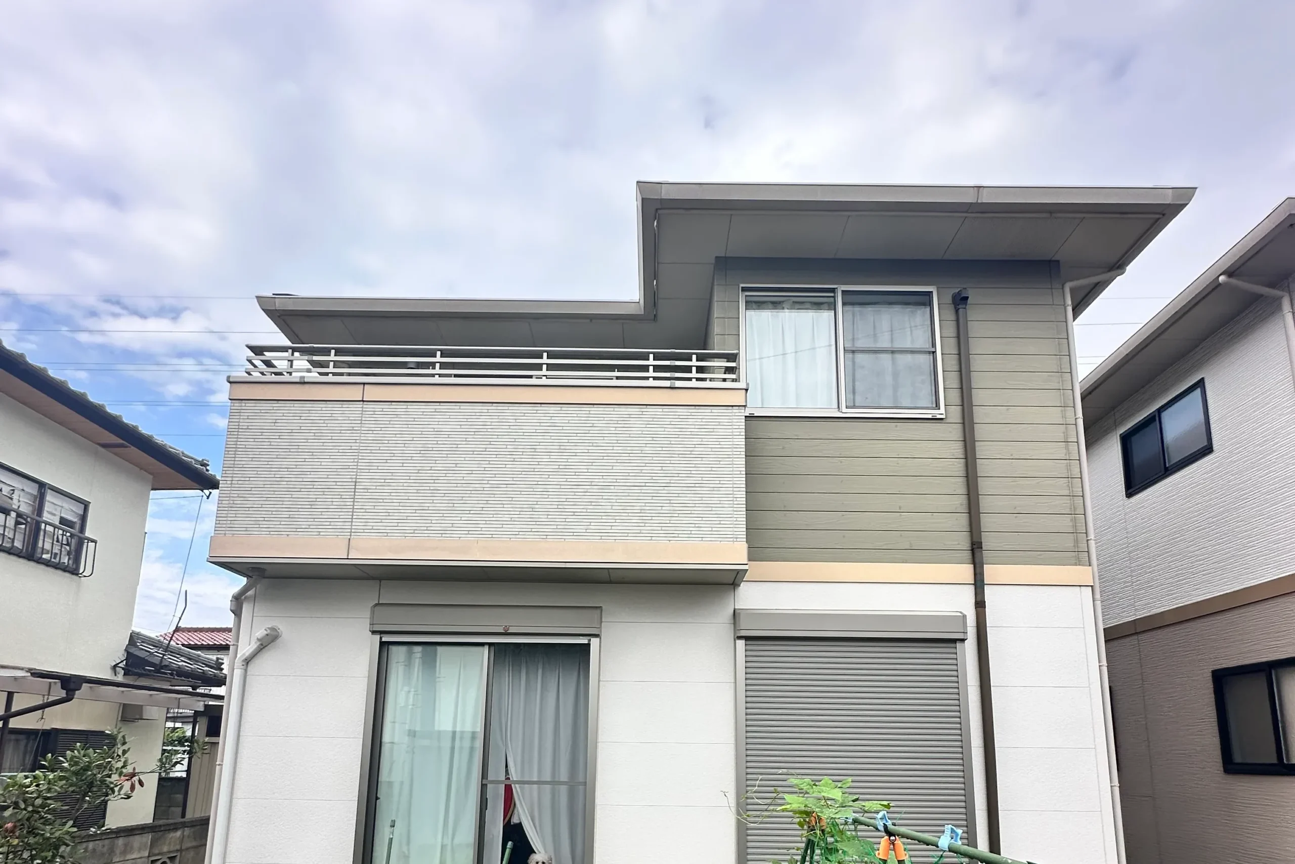 庭側から見た施工前の外壁。ベランダのアクセント壁と日当たりの良い南面の様子。