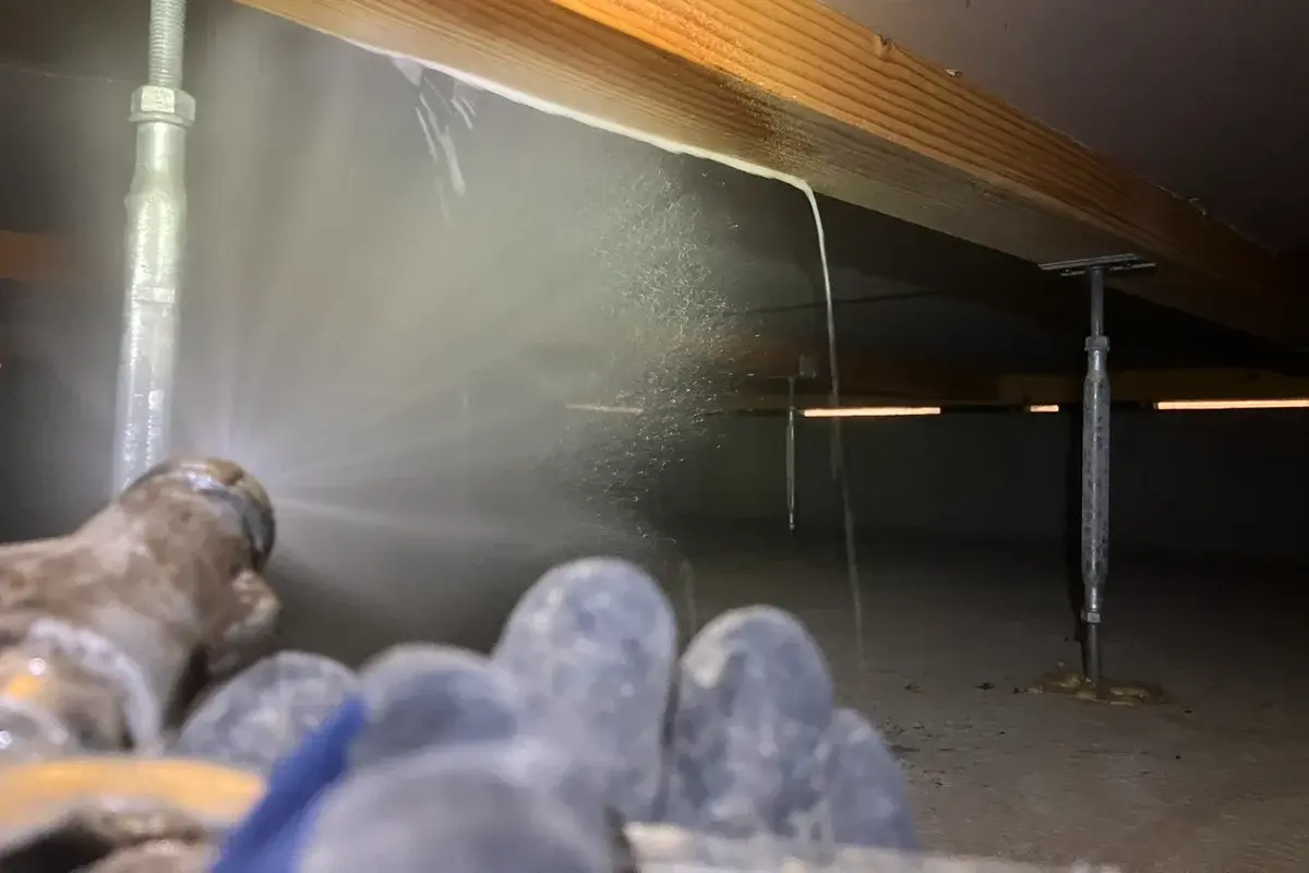 和歌山県海南市の築10年住宅の床下で、木部へシロアリ予防薬剤を散布している様子