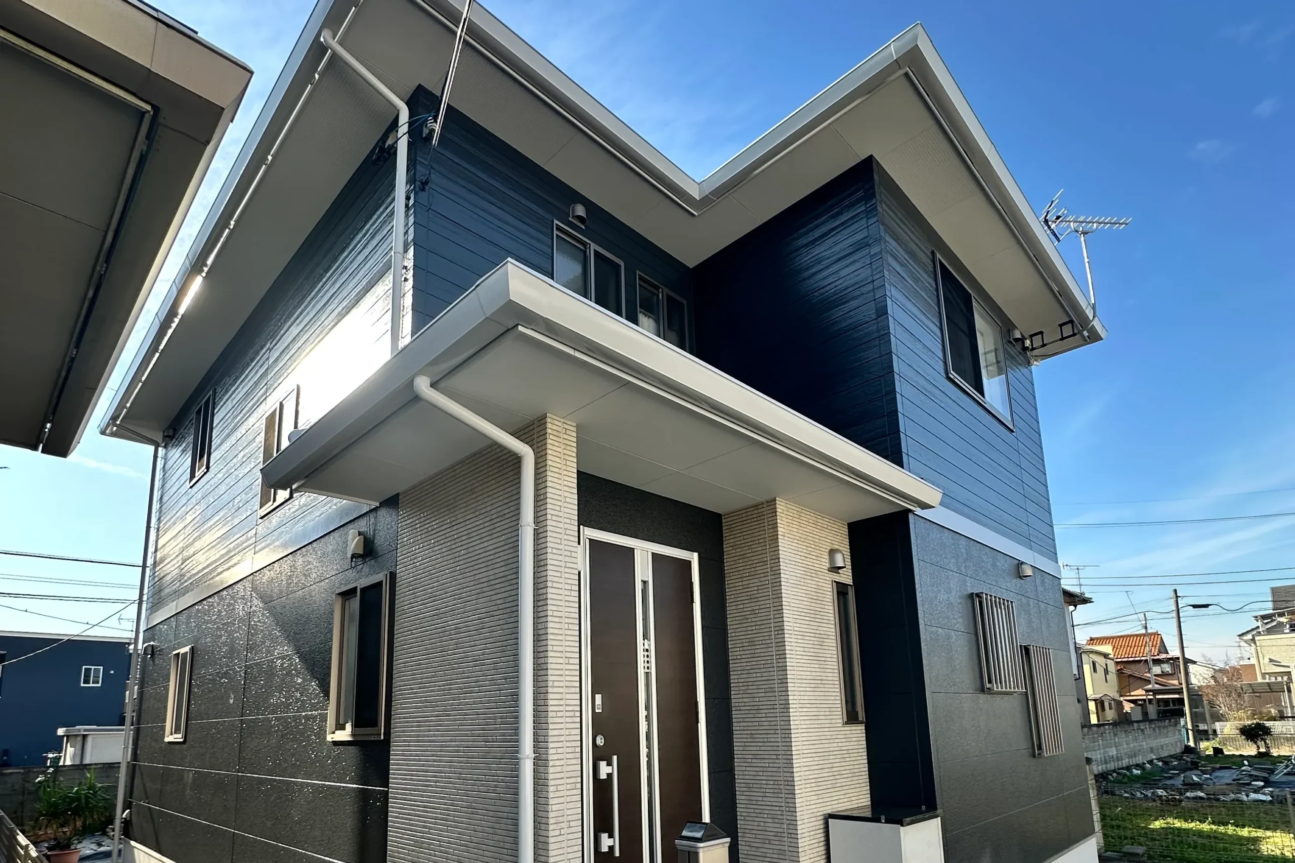 群馬県前橋市の築10年戸建て。ネイビーと石目調アクセントを組み合わせたモダンな外観の外壁塗装完了後。