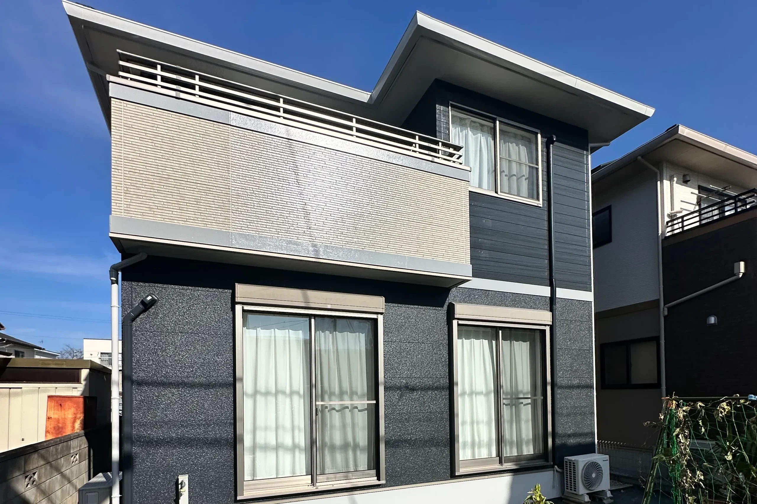 塗り替え後の庭側。深みのあるネイビーと光沢のある屋根塗装でリフレッシュされた全景。