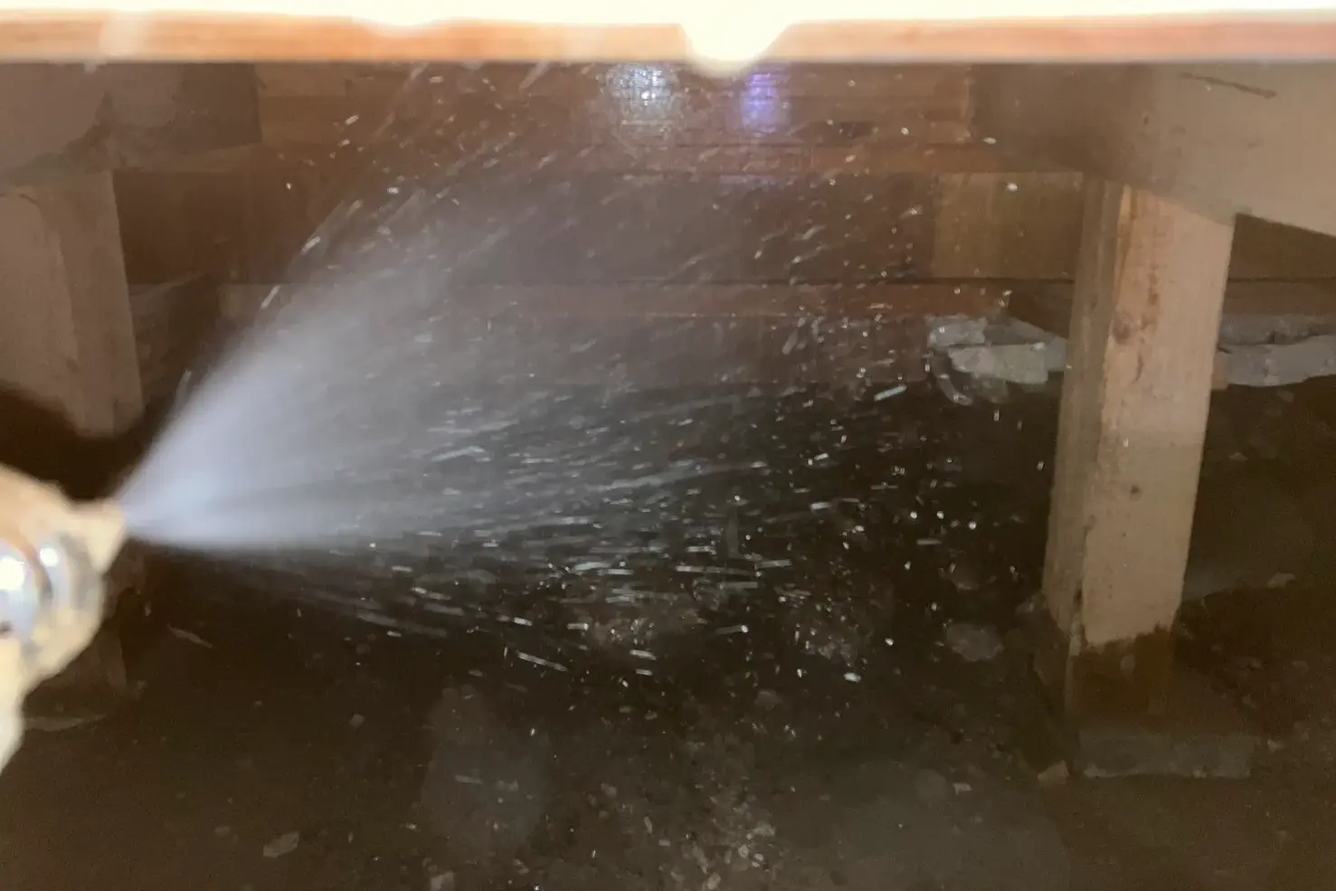 土台と土壌に薬剤を高圧散布している作業風景