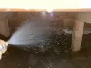 土台と土壌に薬剤を高圧散布している作業風景