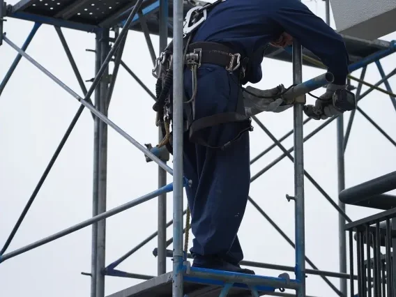 外壁・屋根リフォーム工事のため足場を設置する作業員の様子