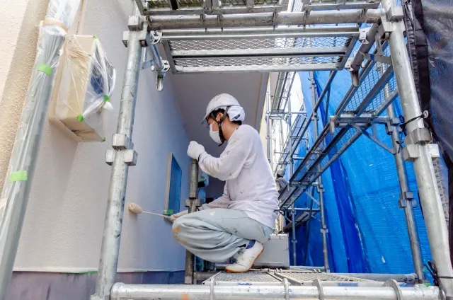 外壁塗装工事を行う作業員