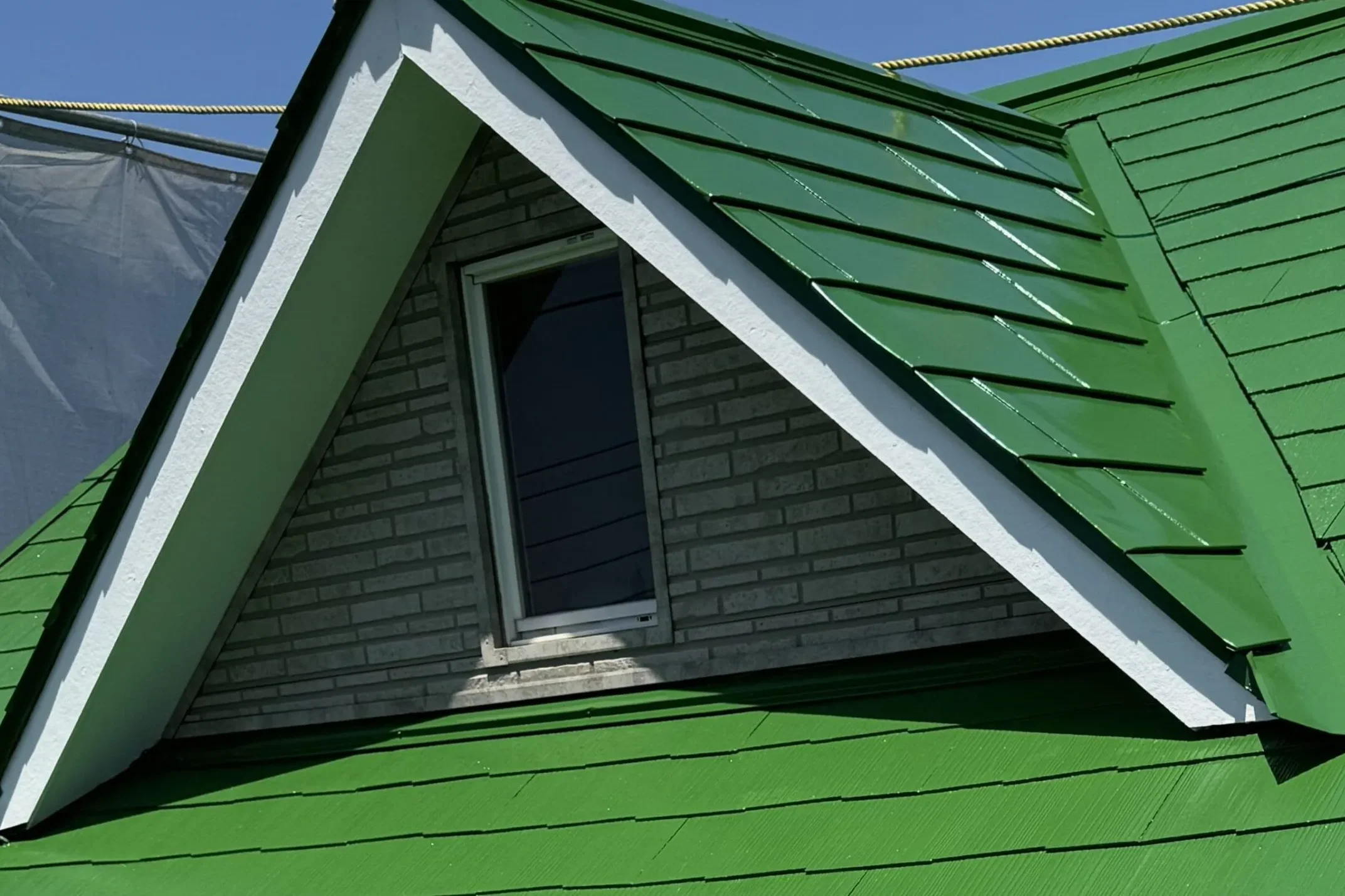 戸建て住宅の屋根塗装施工後の様子（緑色の塗料で塗り替えた屋根）
